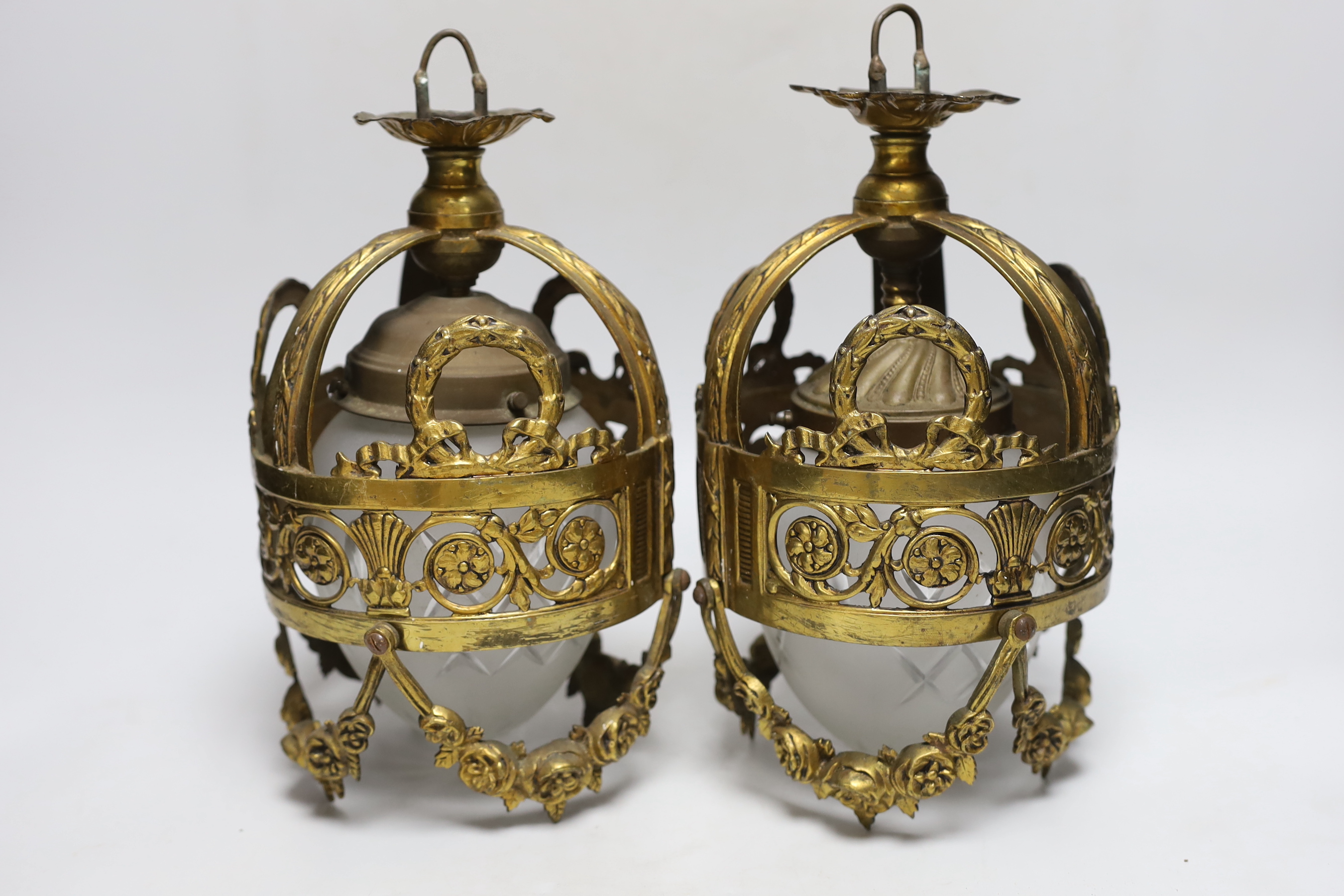 A pair of hanging lanterns, with interior glass shades 28cm high